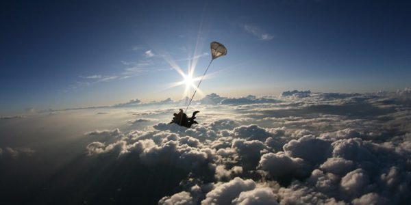 tandem skydiver in freefall with clouds