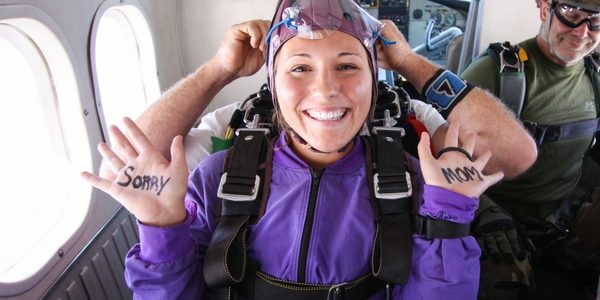 tandem student writes on hands for skydiving video